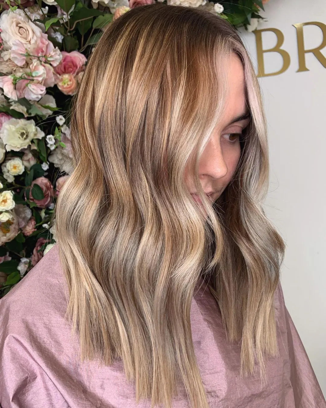 Girl at the hairdressers with honey-blonde wavy hair.