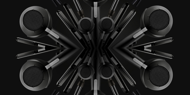 A mirrored image of black CLOUD NINE straighteners, curlers and hair dryers on a black background. The products fan out from the centre.