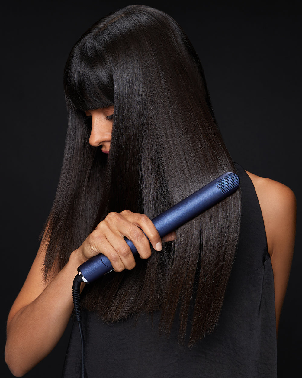 Model straightening her long, black hair with the 2-in-1 Contouring Iron Pro.