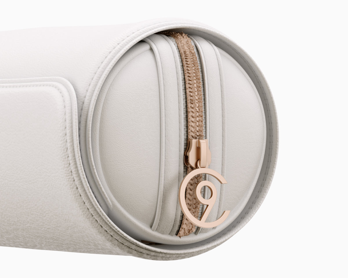 A close up image of the rose gold C9 logo on the CLOUD NINE Luxury White Faux Leather Roll Bag.
