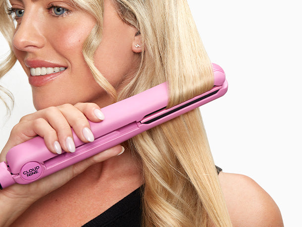 Close up of a blonde model curling her hair with the Poodle Skirt Pink Retro Iron.