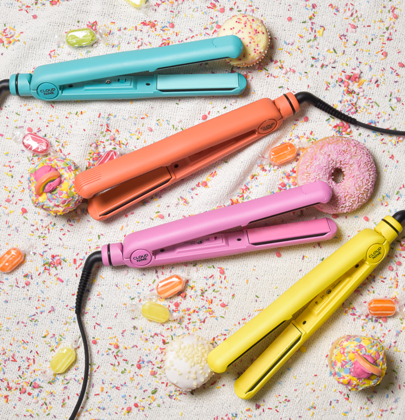 An image showcasing the entire Retro Iron range in blue, orange, pink and yellow. There are sweets and donuts in the background.