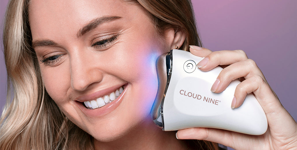 model smiling whilst using the revive beauty device device on her face 