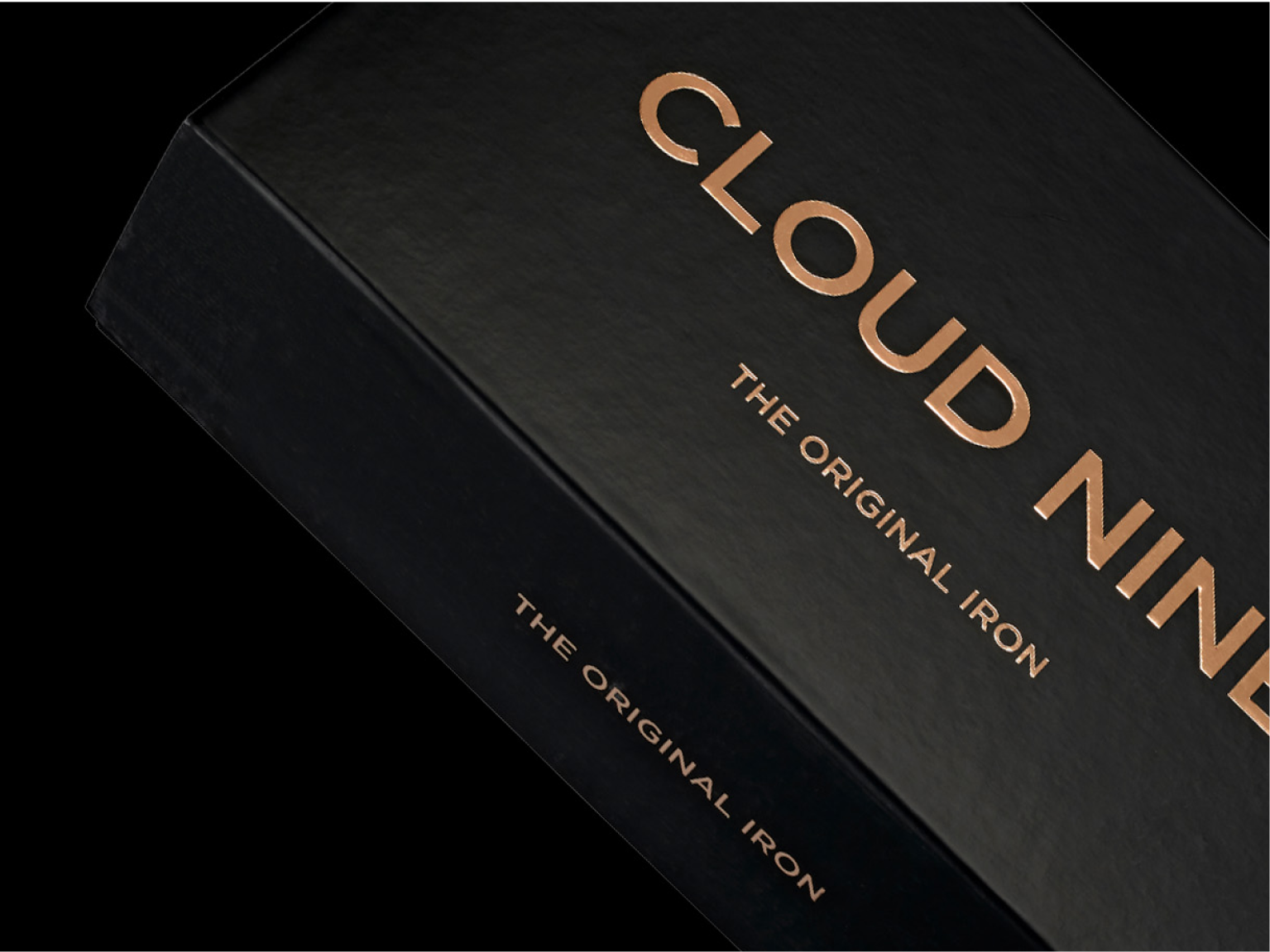 Close up of the CLOUD NINE Original Iron packaging in black, with a black background. 