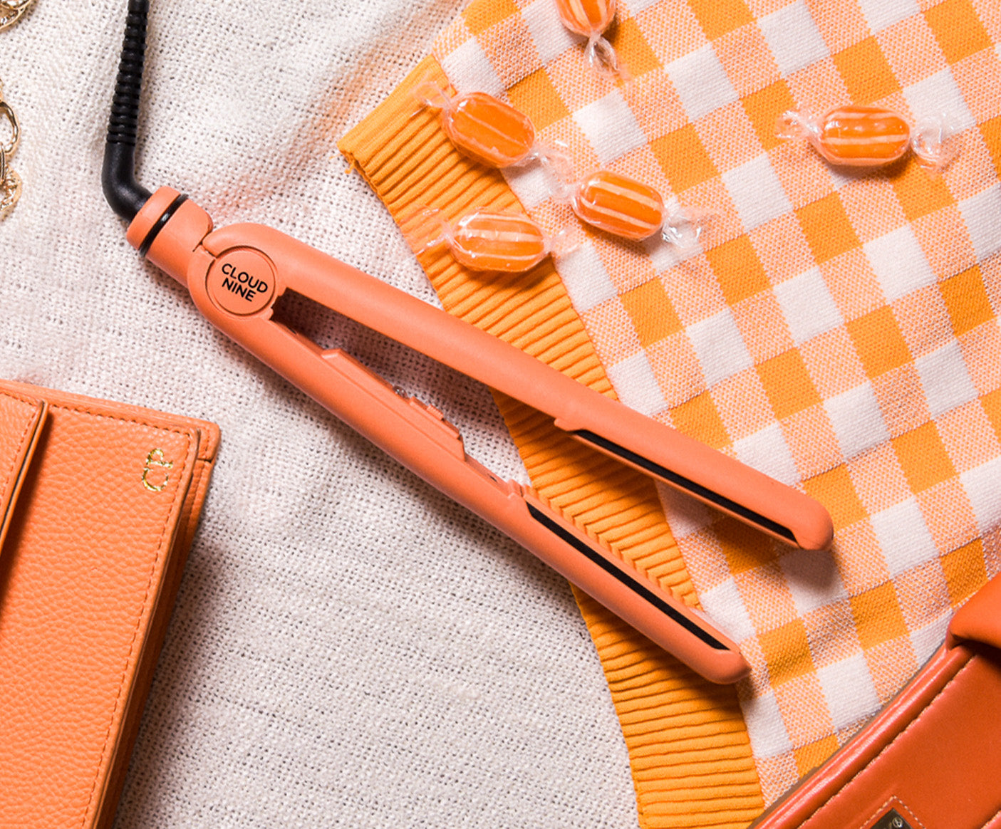 Motel Sunset Mandarin Retro Iron surrounded by other orange accessories including orange sweets and an orange purse.