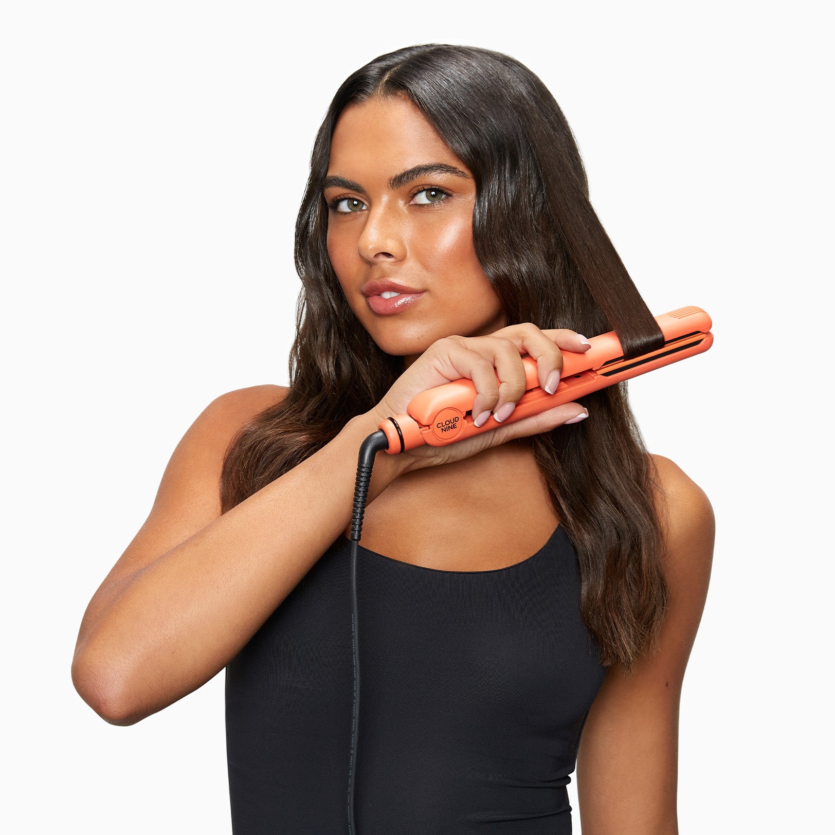 Model curling her mid-length dark brown hair with the Motel Sunset Mandarin Retro Iron.
