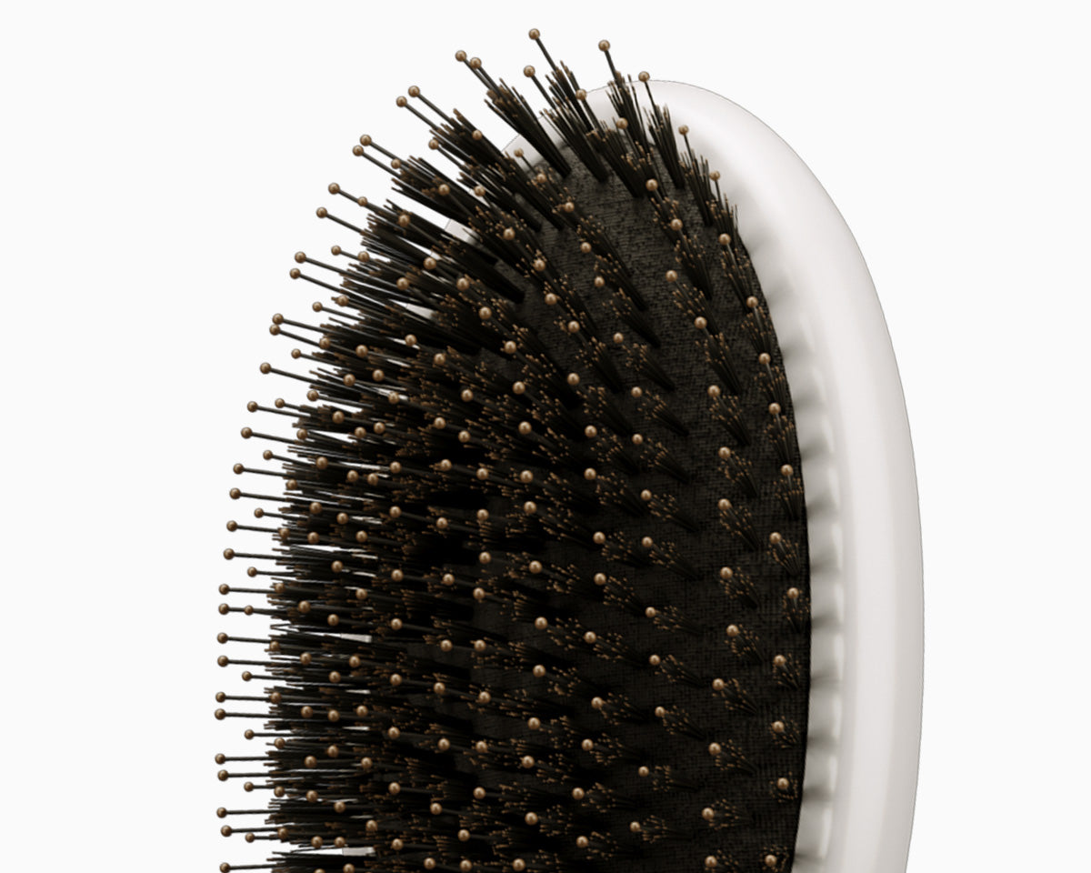 A close-up of the bristles on the white CLOUD NINE Dressing Brush.
