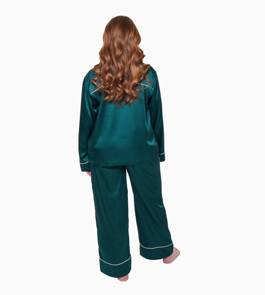 Model facing backwards wearing the dark green pyjama set  including a long sleeved pyjama shirt and trousers.