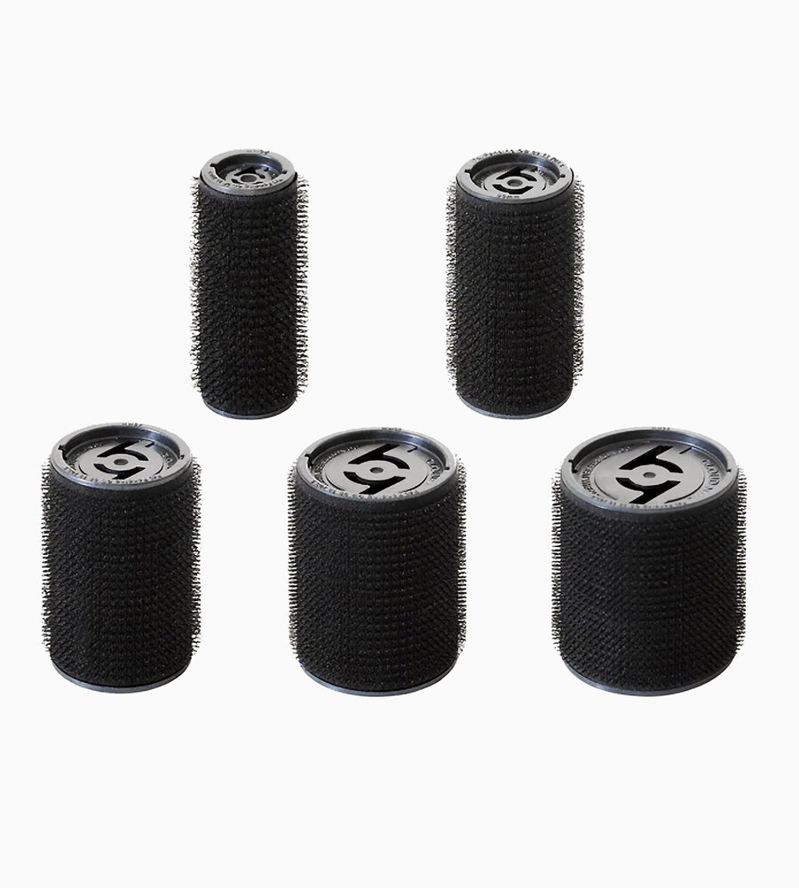 Top angle view of five The O hair rollers in five varying sizes.