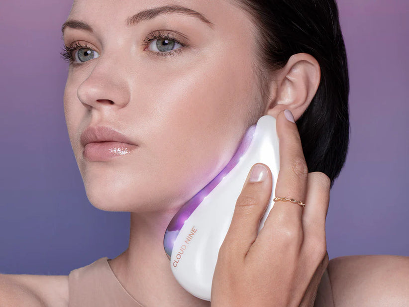 head shot of model using redefine beauty device on her cheek bone