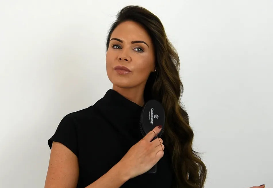 Model brushing her long brown wavy hair with a CLOUD NINE Round Brush.