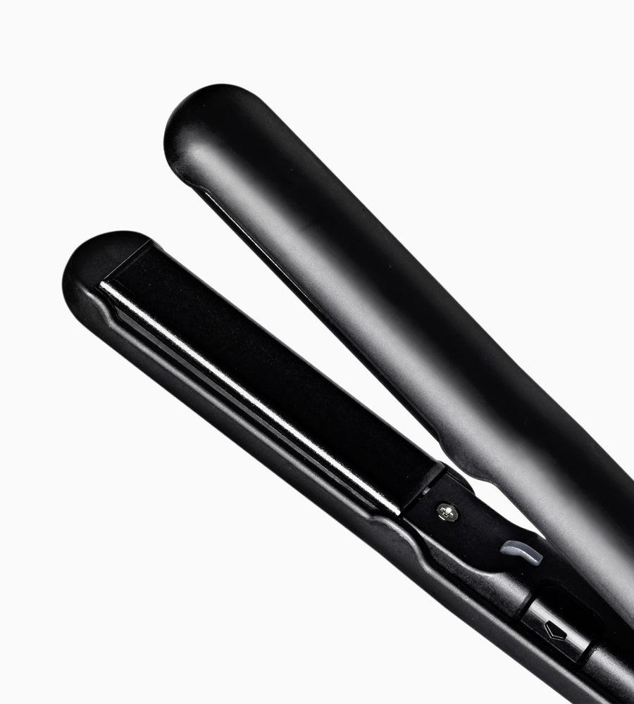Cropped view of ceramic plates on black Micro Iron hair straightener.