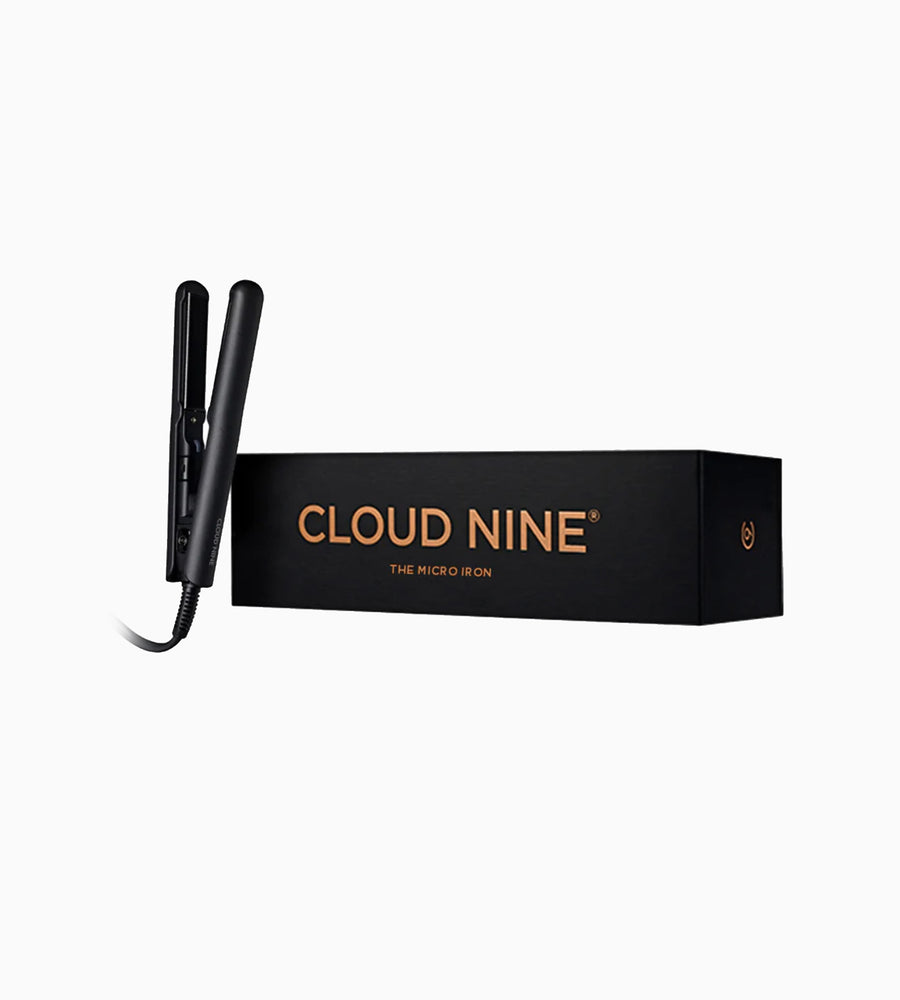 A black Micro Iron hair straightener next to packaging.