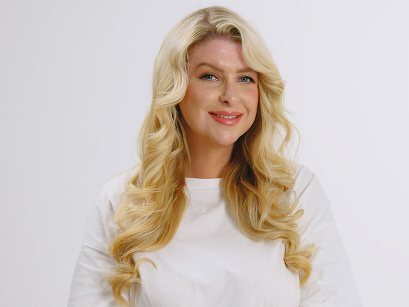 Model with long blonde wavy hair styled using the 2-in-1 Contouring Iron Pro.