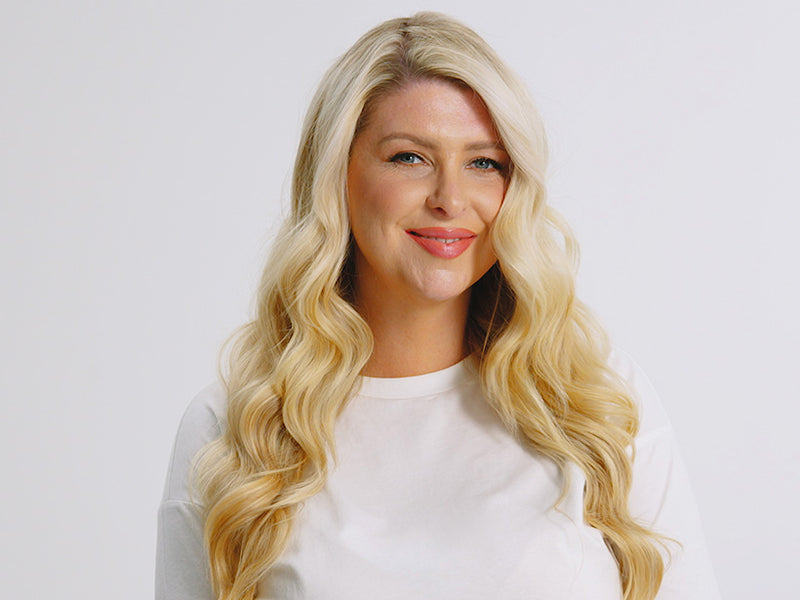 Model with long blonde wavy hair styled using the Curling Wand.