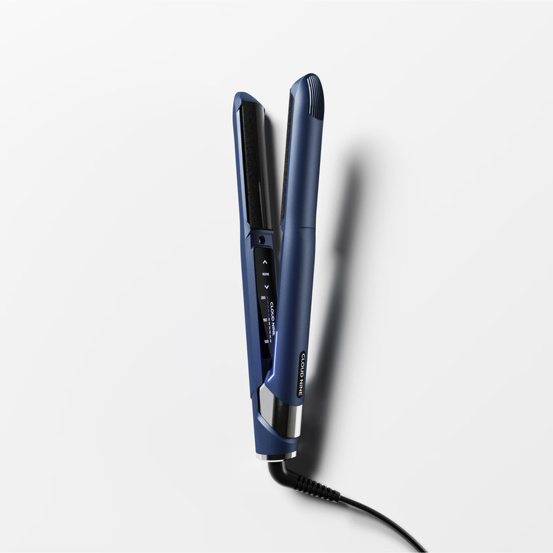 The Contouring Original Iron turned on and angled towards the screen with promotion for Free Travel Hair Dryer worth £99.