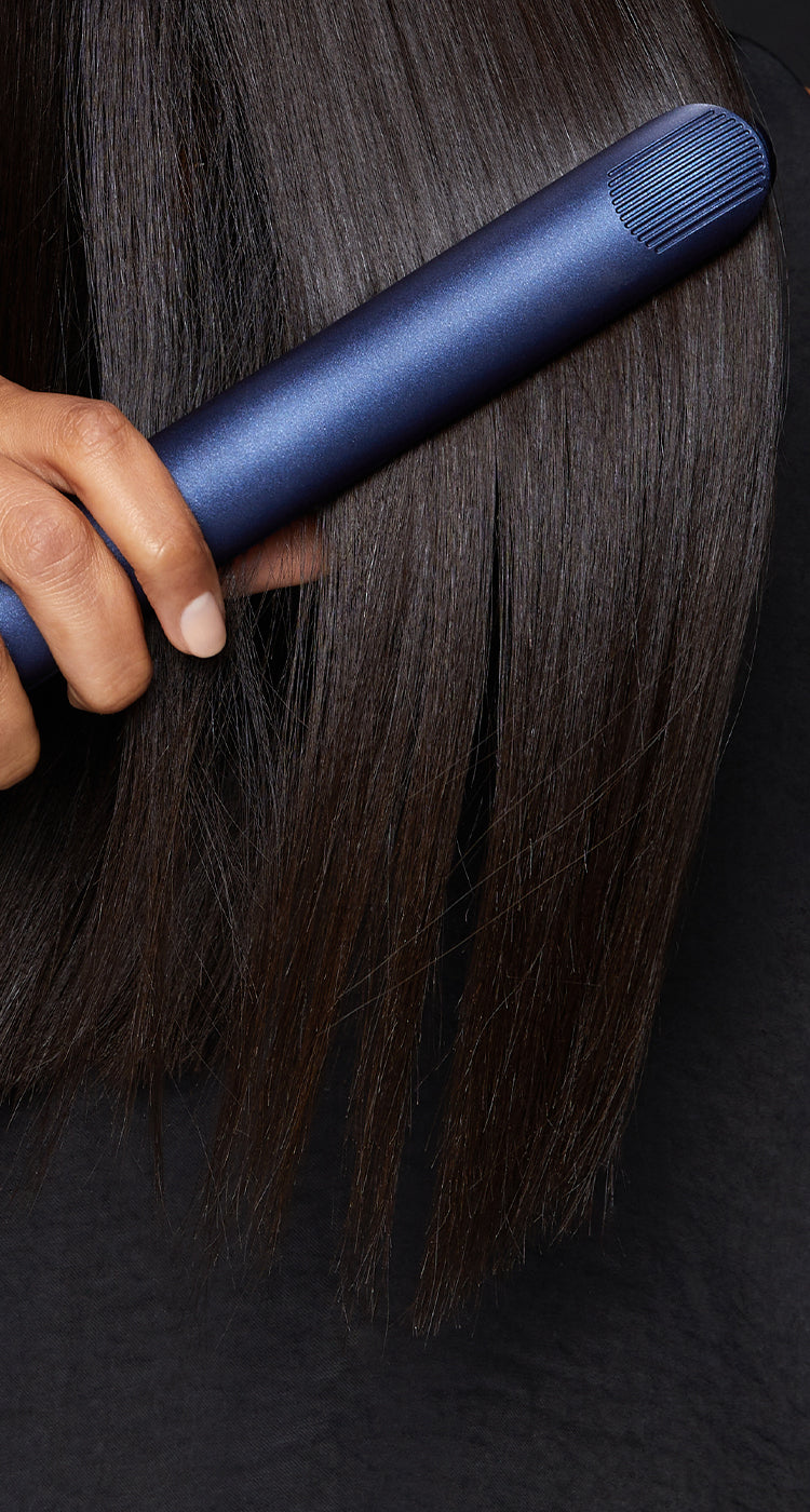 Close up of a model straightening their dark hair with the 2-in-1 Contouring Iron Pro.