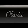 A black hair straightener with the name Olivia monogrammed.