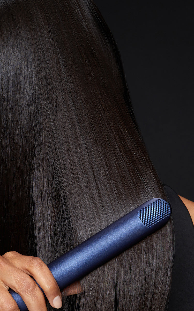 Close up of a model straightening their long, black hair with the 2-in-1 Contouring Iron Pro.