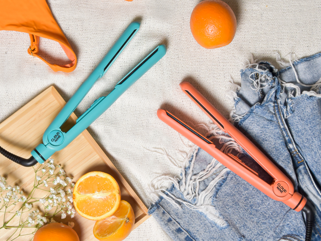 The Soda Fountain Blue and Motel Sunset Mandarin Retro Irons laying on a summer themed background with oranges, a bikini top and denim shorts. 