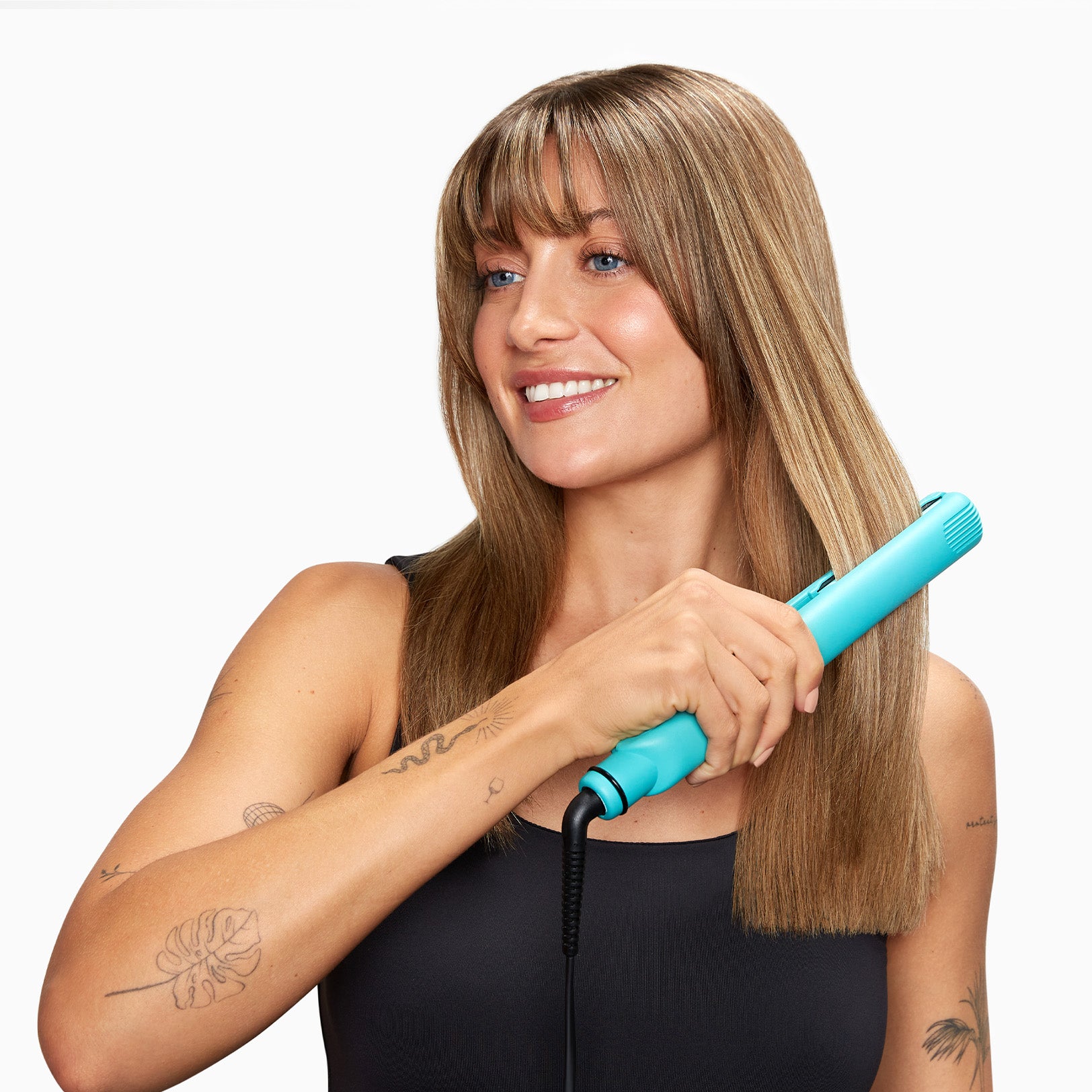 Model with tattoos straightening her light brown hair with the Soda Fountain Blue Retro Iron.