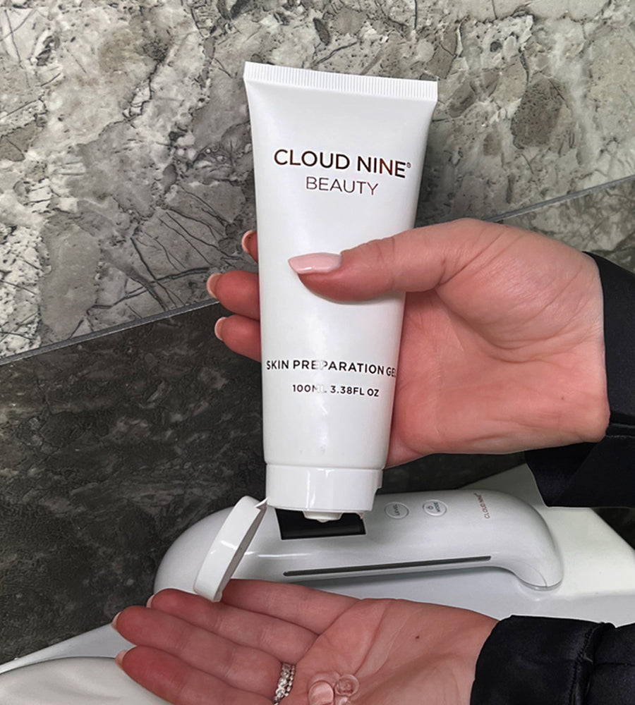 A model squeezing CLOUD NINE skin preparation gel into her hand with the Rejuvenate Beauty Device in the background.