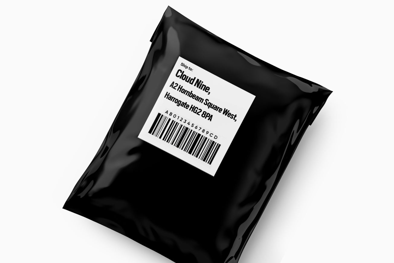 A black package with a white label featuring the address for the CLOUD NINE Trade In service. 
