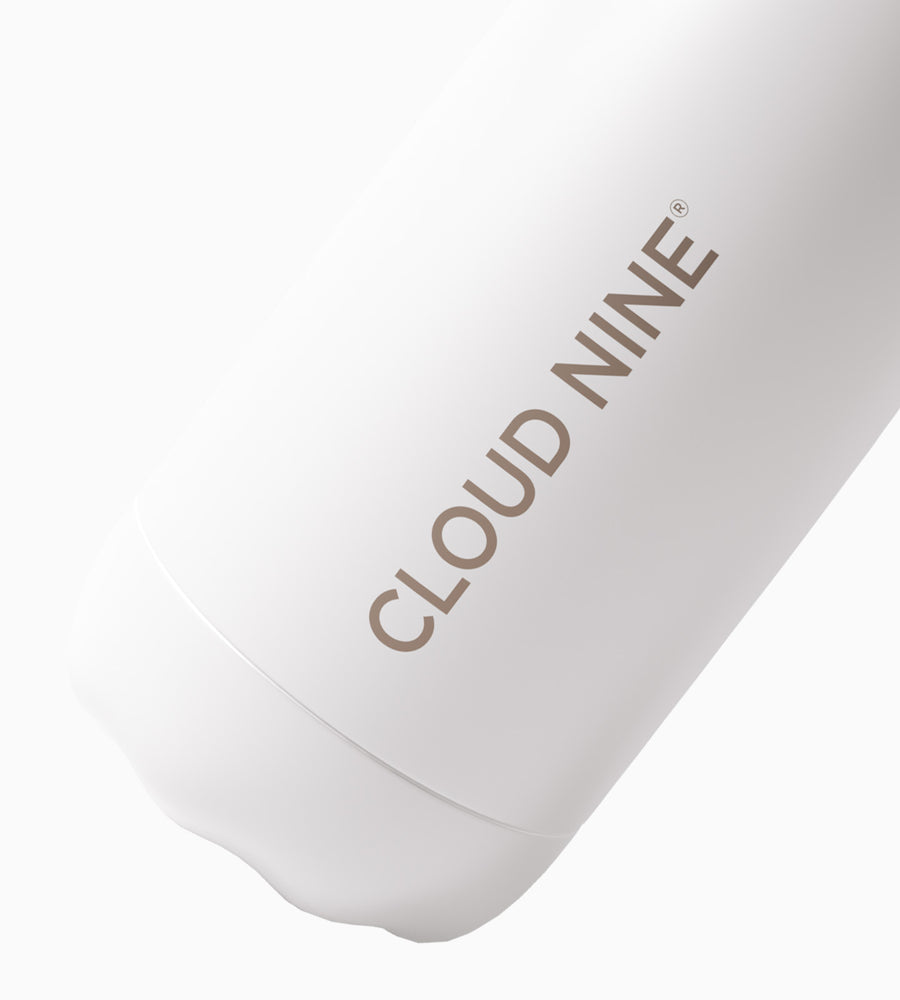 A white water bottle tilted to right with CLOUD NINE lettering in gold.